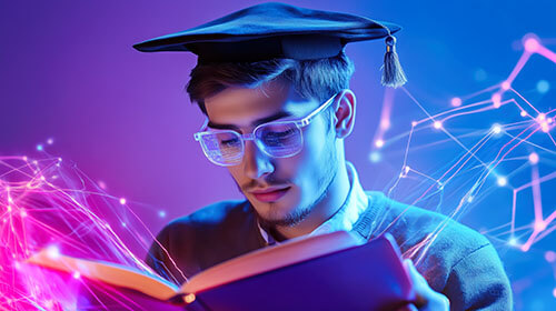 Young adult male in graduation cap reading a book