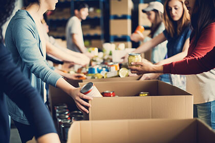 People filling boxes with canned goods